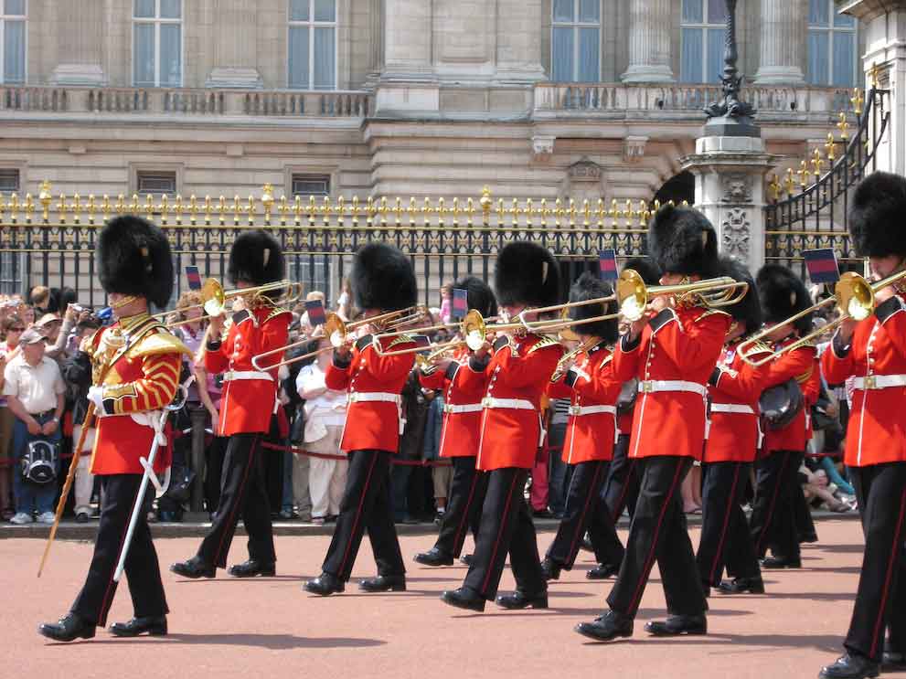 The Royal Guard playing trumpets outside Buckingham Palace in London, a famous tourist attraction for visitors and summer school students